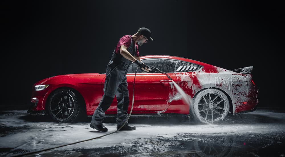 Man cleaning a red vehicle at a car wash near Spring