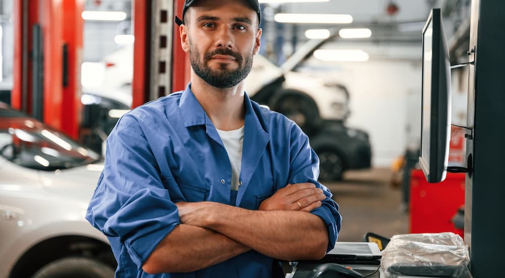 Mechanic crossing their arms and standing in an auto shop