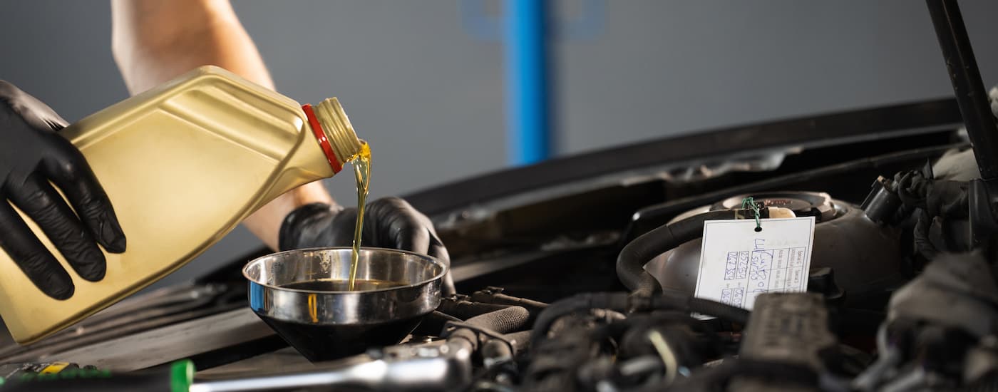 Oil being poured out of a bottle into a car's engine