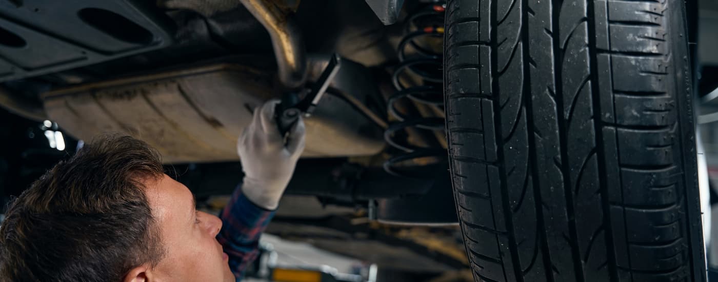 Mechanic adjusting the suspension of a vehicle