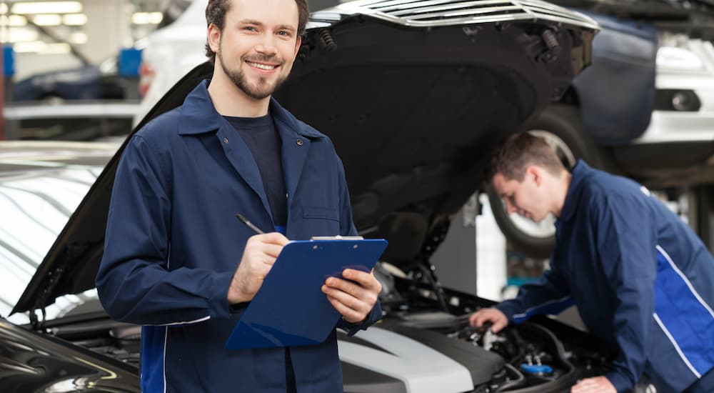 A mechanic holding a clipboard before performing car maintenance