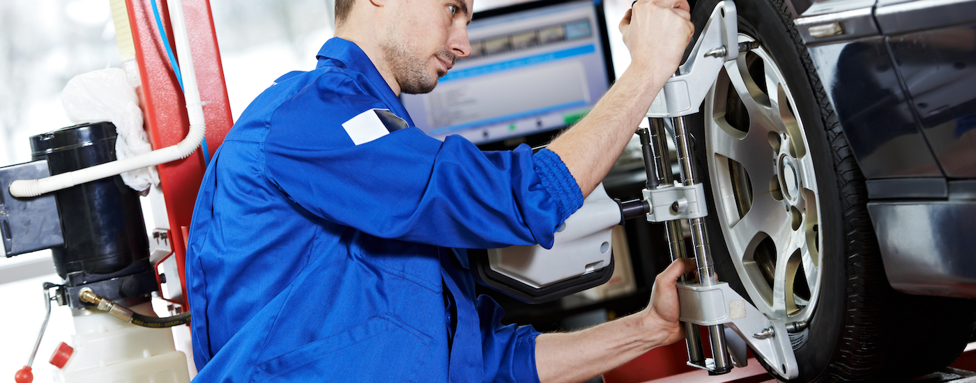 Mechanic performing service on a car's wheel.
