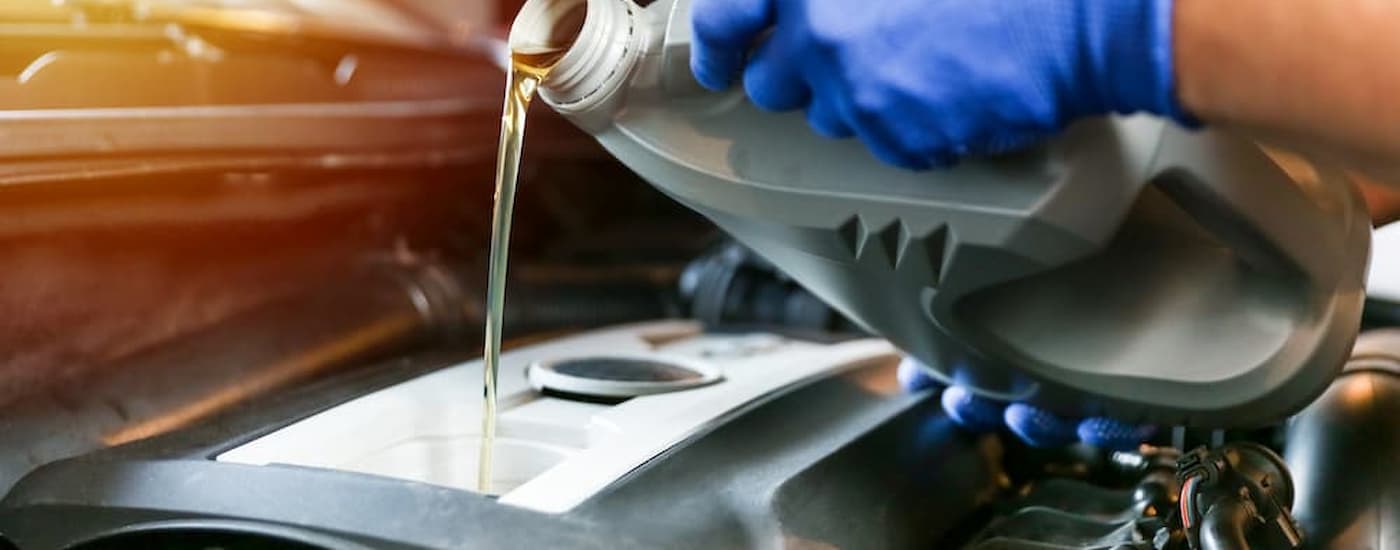 Mechanic adding oil to a vehicle