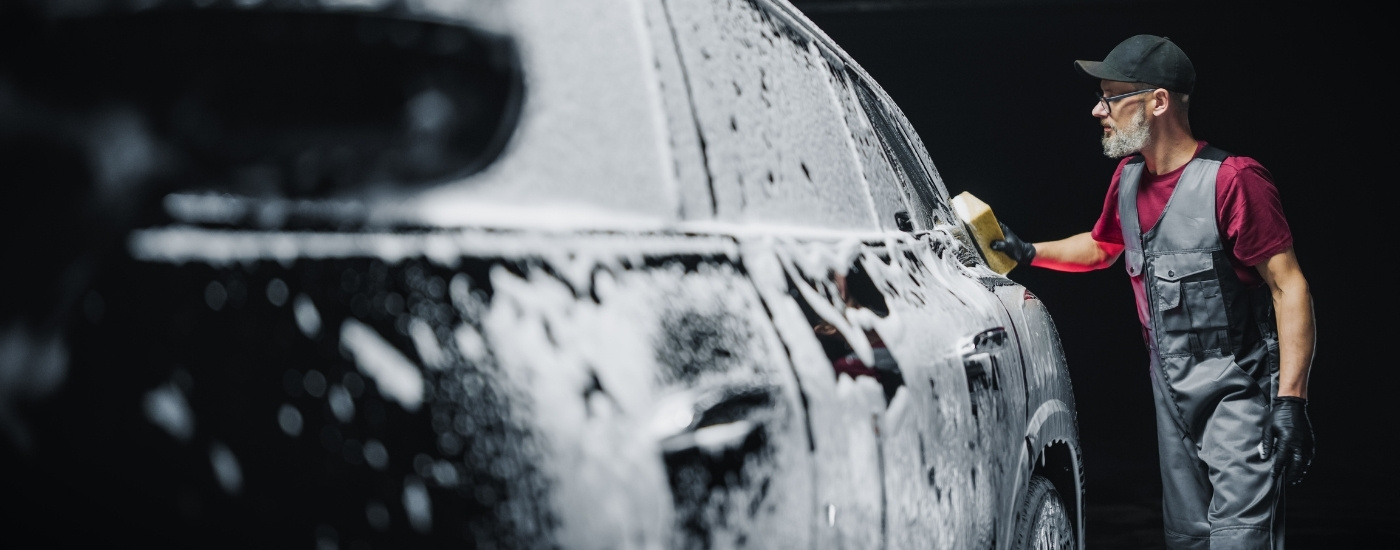 Technician washing a vehicle