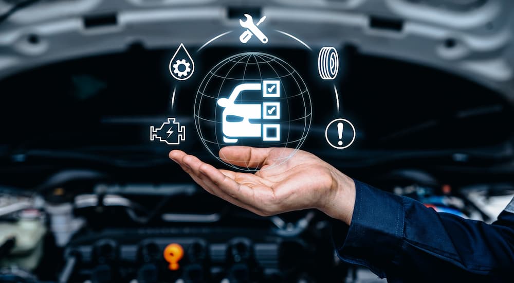 A hand holding a graphic of car maintenance warnings