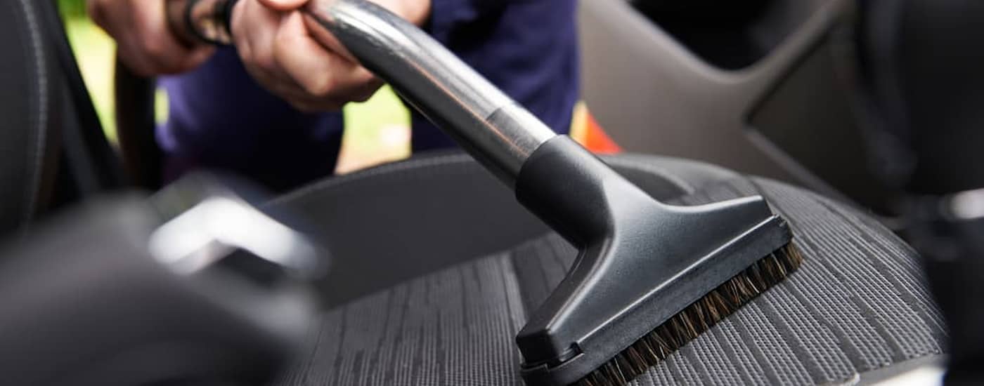 A vacuum cleaner being used in a car.
