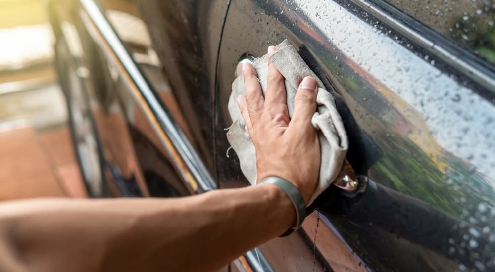 Hand wiping down a car.