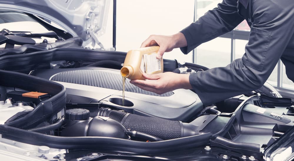 Oil can being poured into an engine.